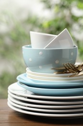 Beautiful ceramic dishware and cutlery on wooden table outdoors