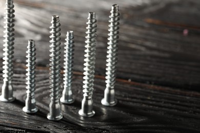 Photo of Countersunk screws on wooden table, closeup. Space for text