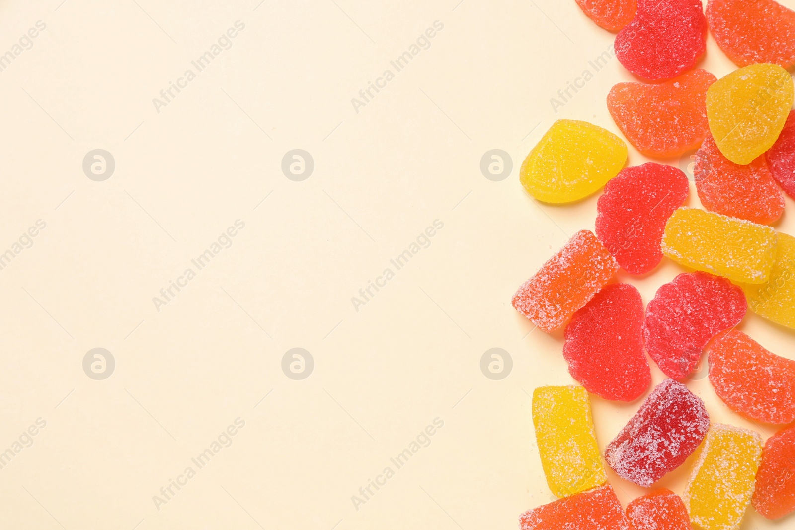 Photo of Many tasty jelly candies on light background, flat lay. Space for text