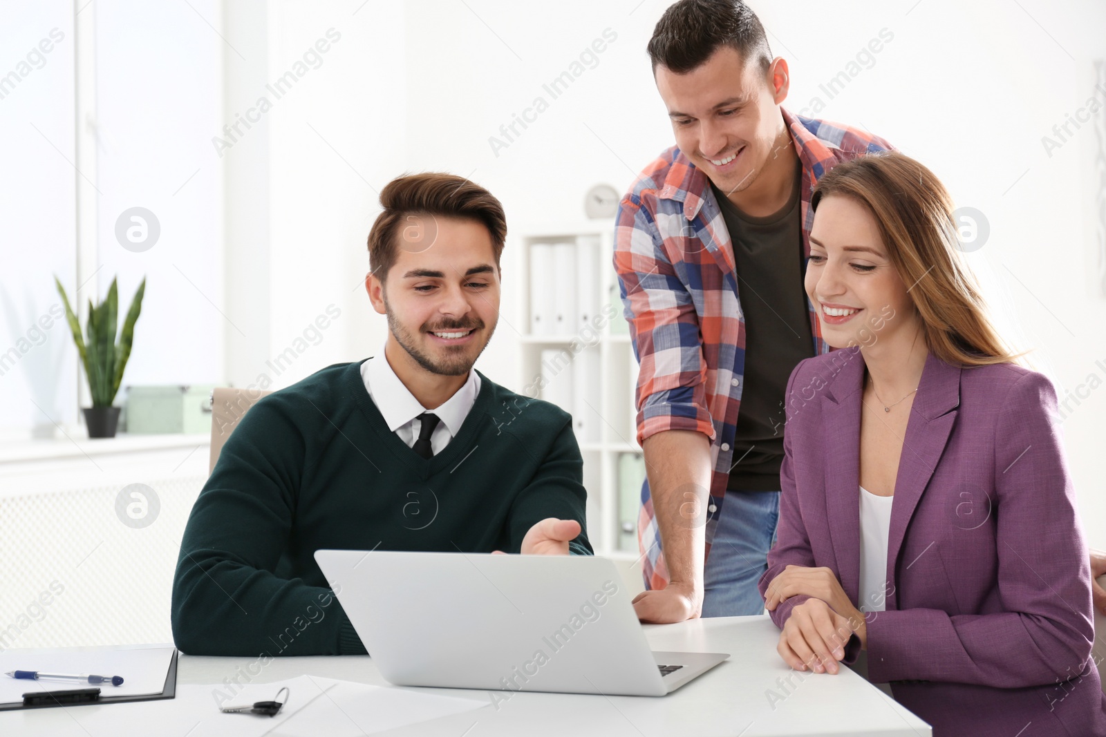 Photo of Real estate agent consulting young couple in office