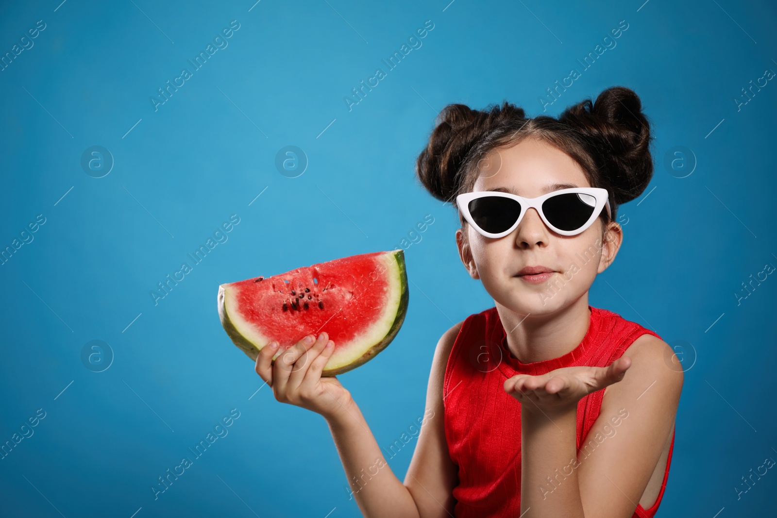 Photo of Cute little girl with watermelon on blue background