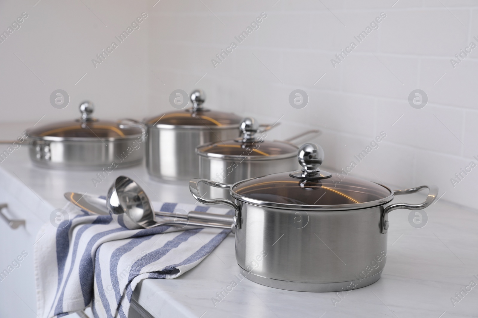 Photo of Set of new clean cookware and utensils on countertop in kitchen