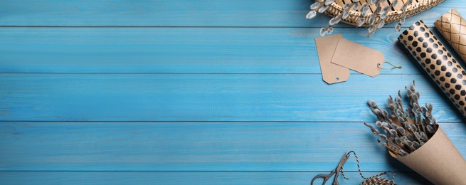 Flat lay composition with pussy willow branches on light blue wooden table, space for text. Banner design