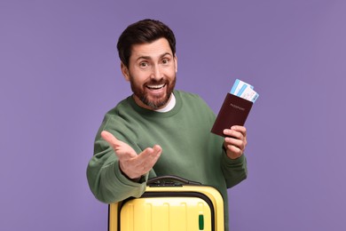 Smiling man with passport, tickets and suitcase on purple background