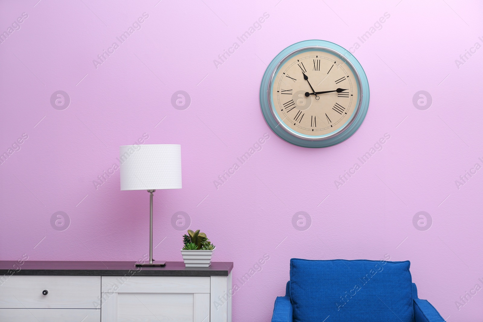 Photo of Room interior with stylish clock on wall. Time of day