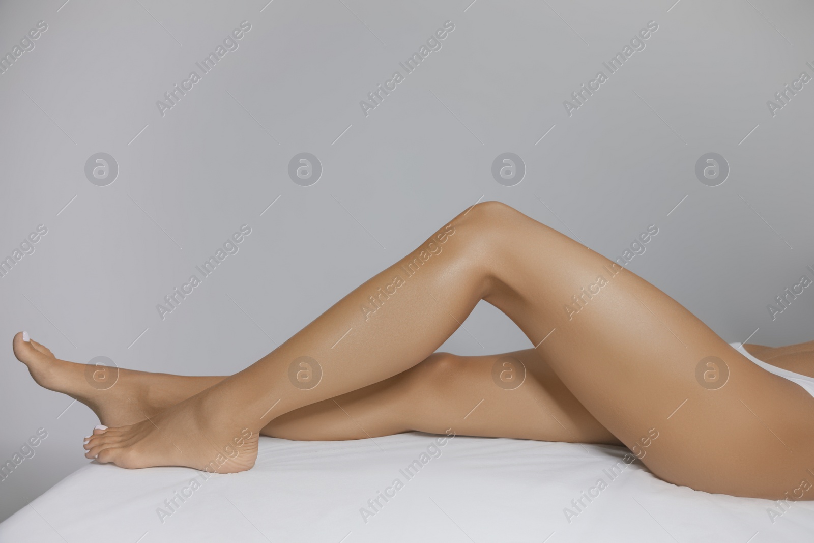 Photo of Young woman showing smooth silky skin after sugaring procedure in salon, closeup