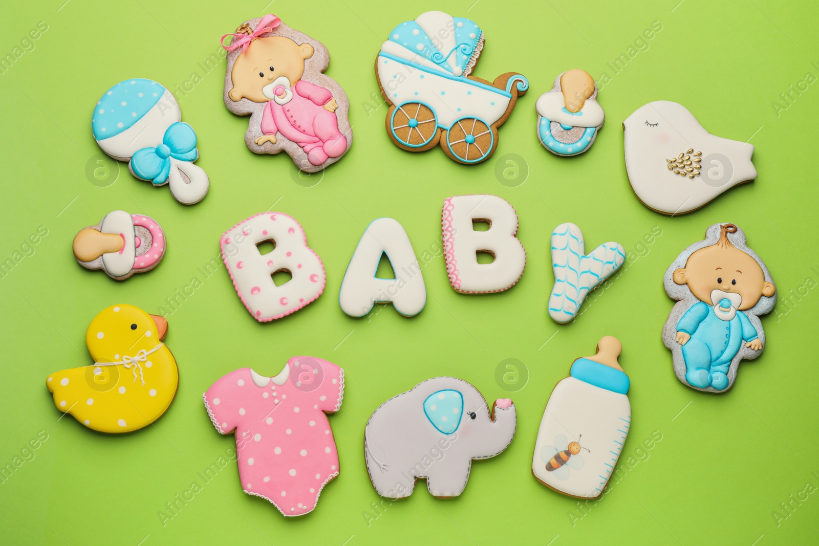Photo of Word BABY and tasty cookies on light green background, flat lay