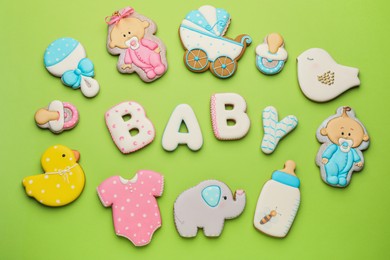 Word BABY and tasty cookies on light green background, flat lay