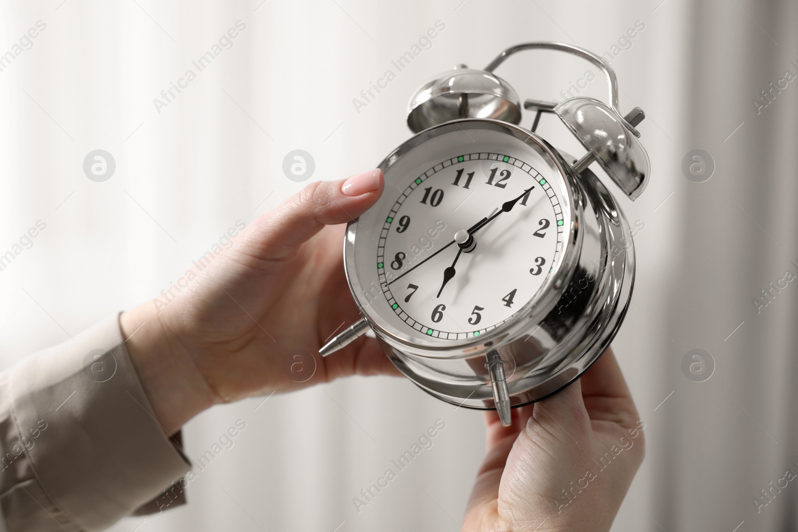 Photo of Woman with alarm clock indoors, closeup view