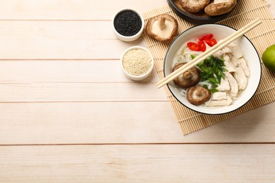 Photo of Delicious ramen with meat and ingredients on wooden table, flat lay. Space for text