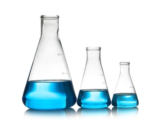 Photo of Conical flasks with liquid on table against white background. Laboratory analysis