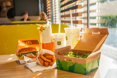 WARSAW, POLAND - SEPTEMBER 16, 2022: Big Mac hamburger, fried potatoes and cold drinks on table in McDonald's cafe
