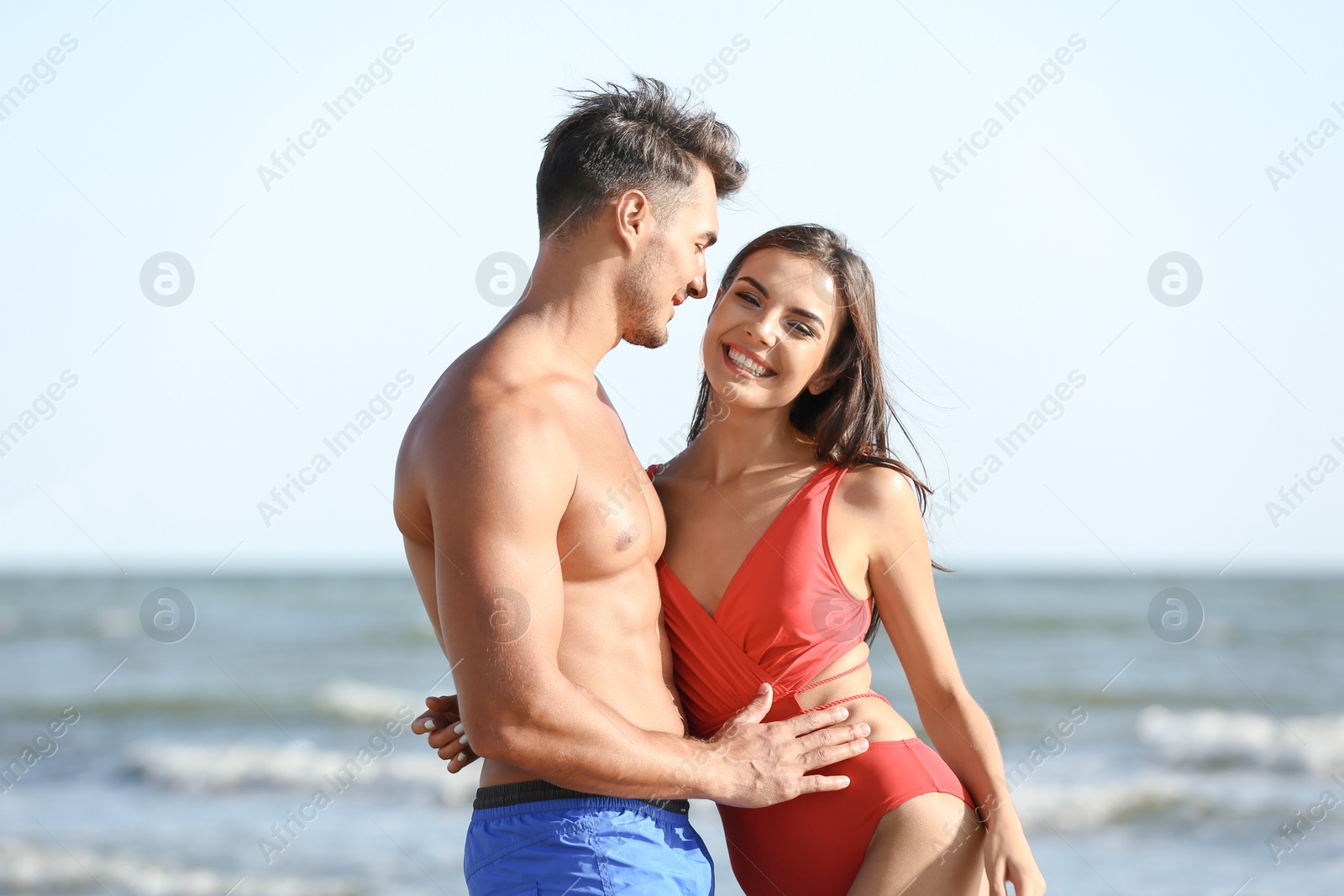 Photo of Happy young couple posing near sea on beach