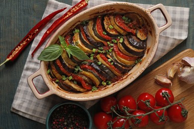 Photo of Delicious ratatouille and ingredients on wooden table, flat lay