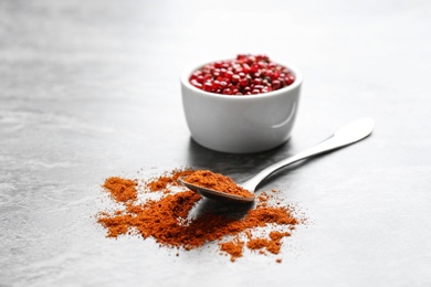 Ground red pepper and corns on grey table