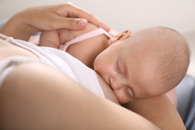 Young woman breastfeeding her little baby at home, above view
