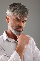 Photo of Portrait of confident man with beautiful hairstyle on light grey background