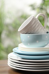 Photo of Beautiful ceramic dishware and cup on wooden table outdoors