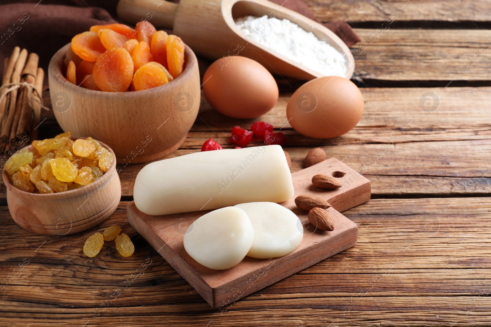 Photo of Marzipan and other ingredients for homemade Stollen on wooden table. Baking traditional German Christmas bread