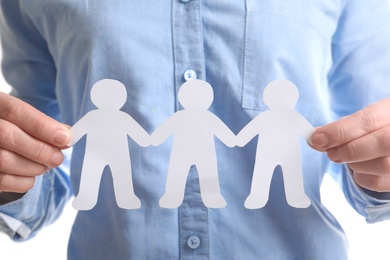 Photo of Young woman holding paper people, closeup. Unity concept