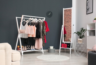 Wardrobe rack with women's clothes and shoes in dressing room