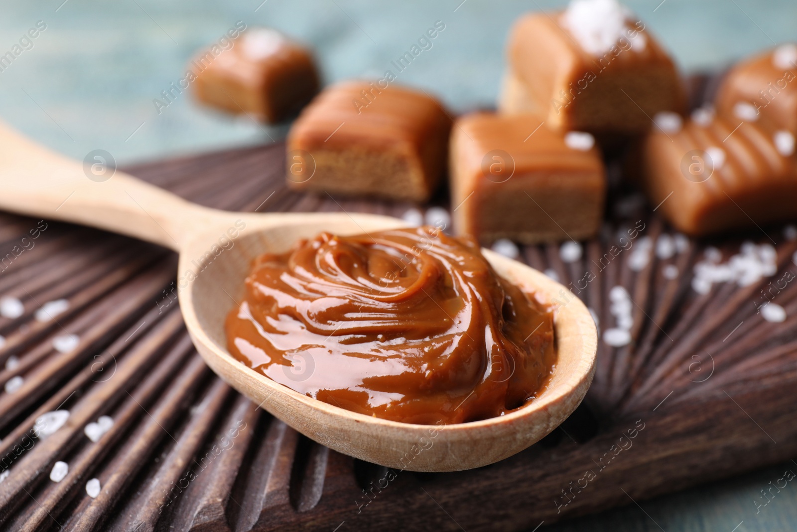 Photo of Salted caramel in spoon on board, closeup