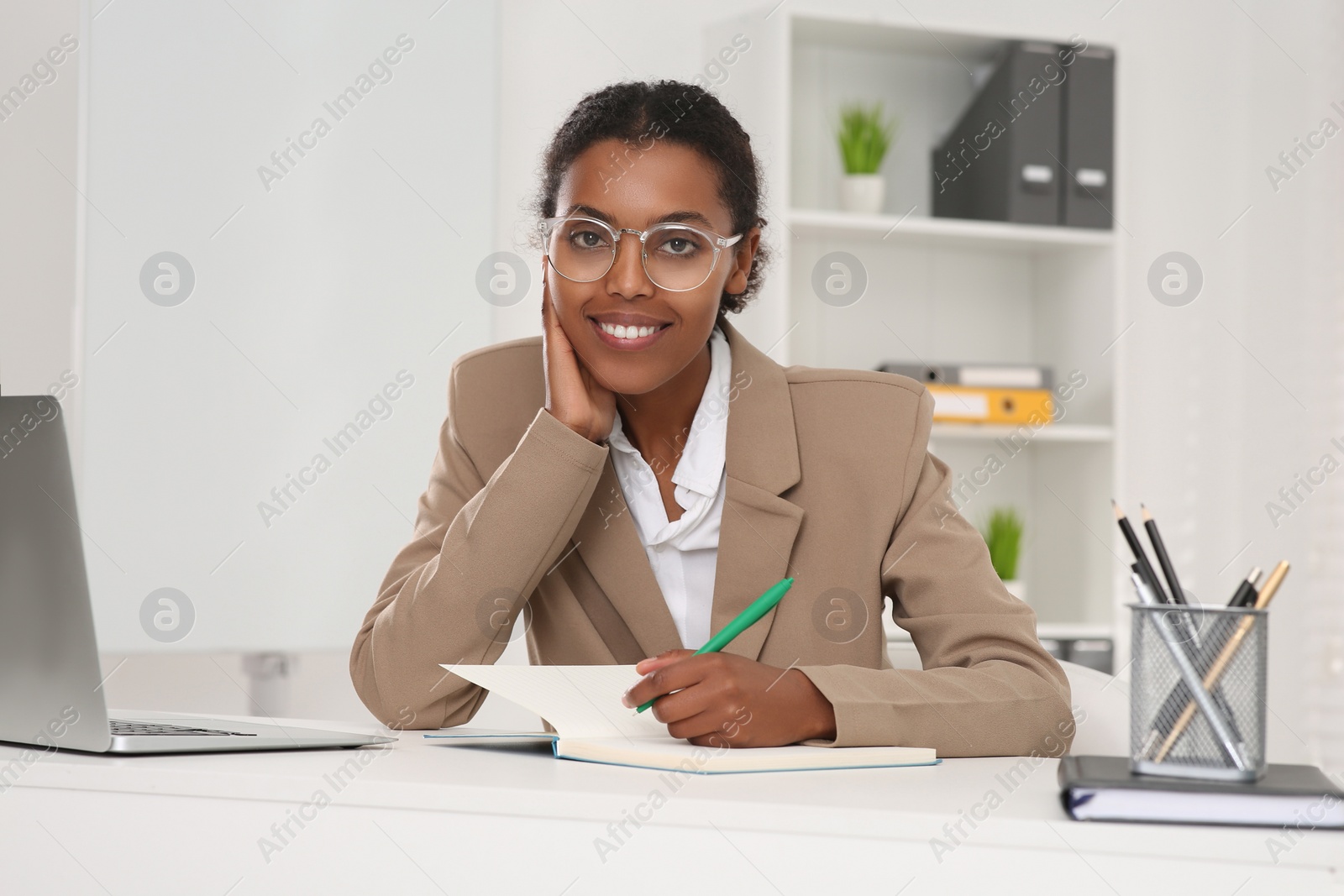 Photo of African American intern working at white table in office