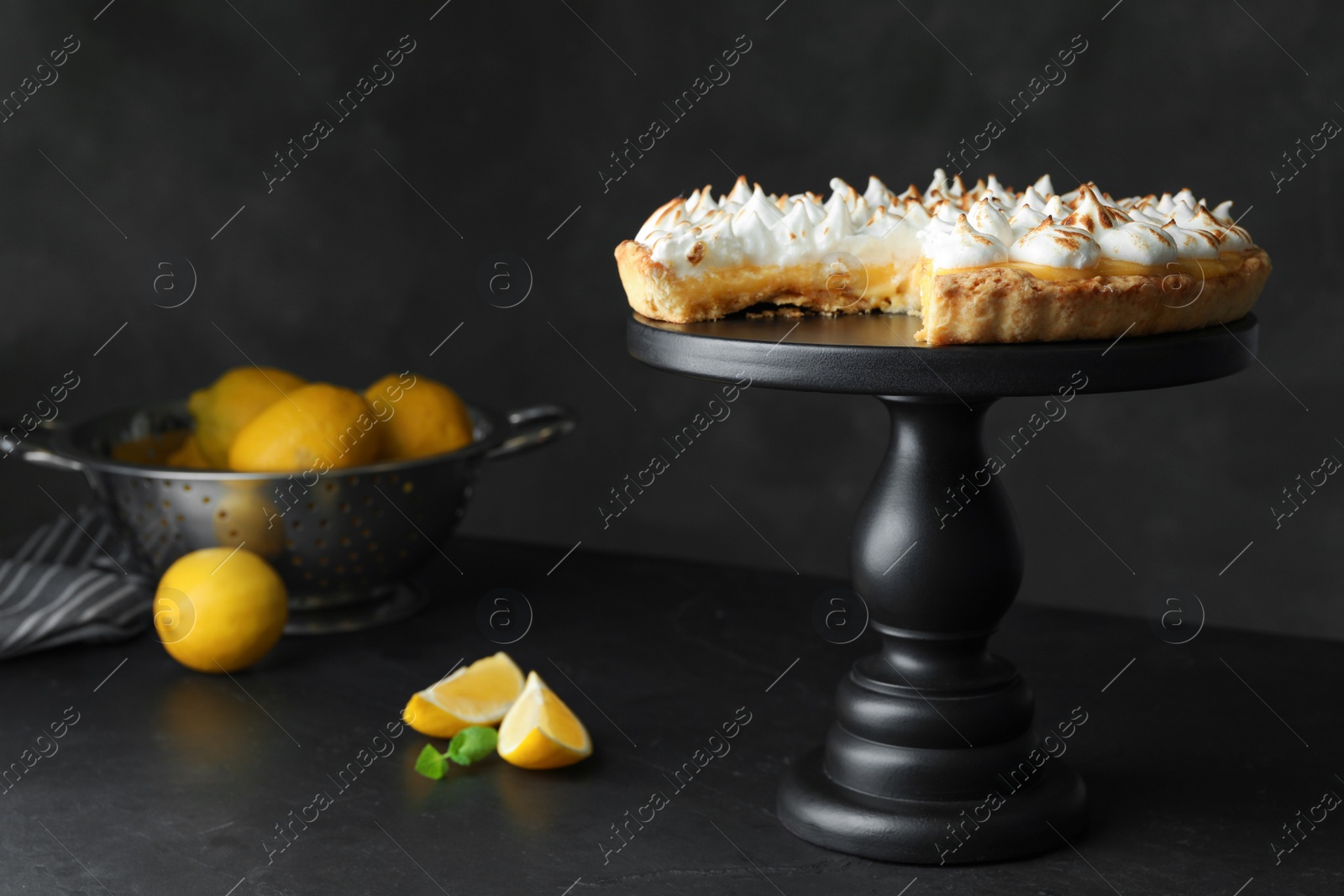 Photo of Stand with delicious lemon meringue pie on dark grey table, space for text