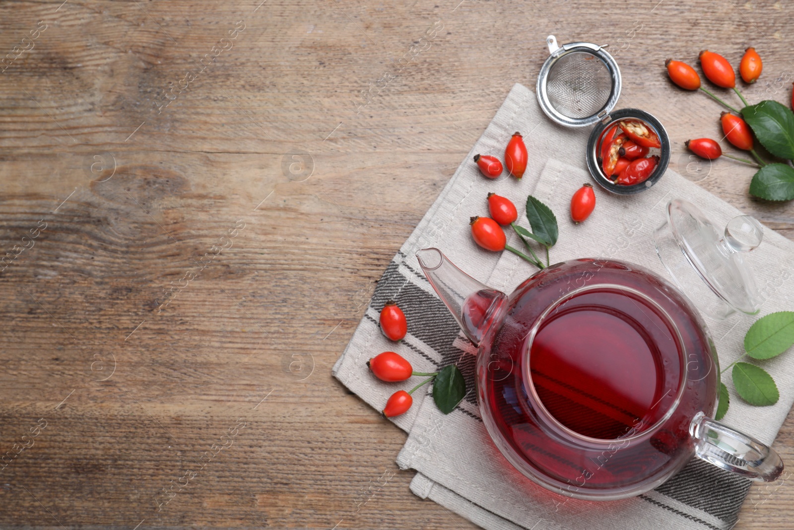 Photo of Flat lay composition with aromatic rose hip tea on wooden table. Space for text