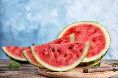 Photo of Wooden board with juicy watermelon slices on table