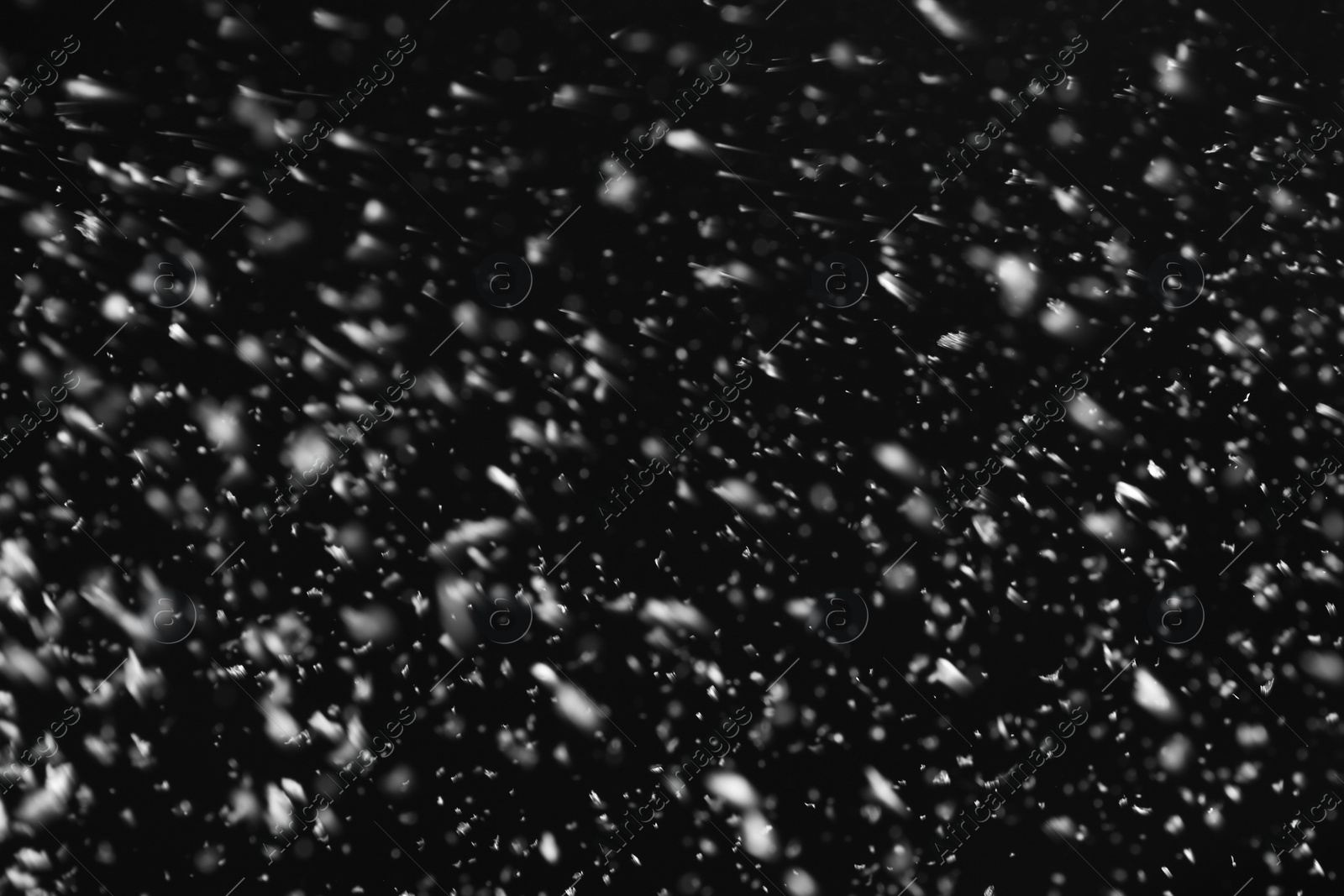 Photo of Snow flakes falling on black background. Winter weather