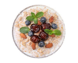 Photo of Tasty wheat porridge with milk, dates, blueberries and almonds in bowl isolated on white, top view