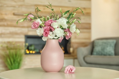 Vase with beautiful flowers on table in living room