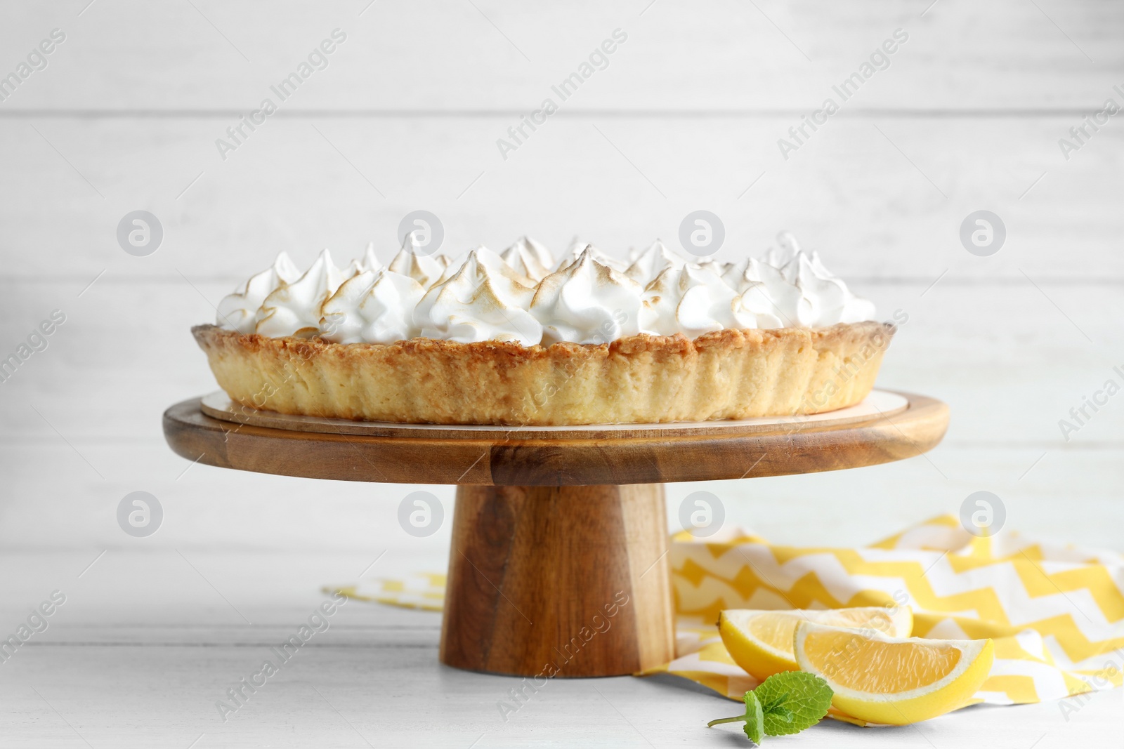 Photo of Stand with delicious lemon meringue pie on white wooden table