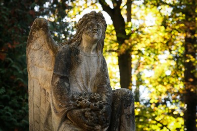 Photo of Beautiful statue of angel at cemetery, space for text