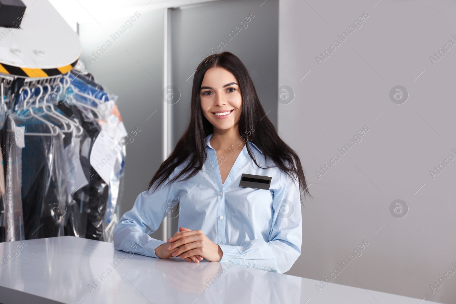 Photo of Female worker near counter at modern dry-cleaner's