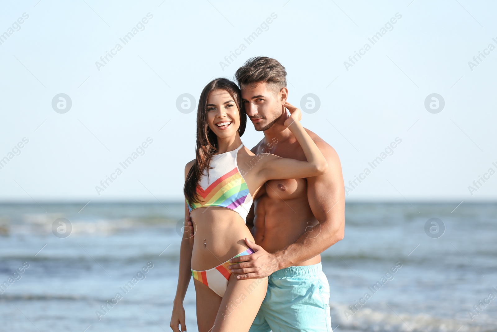 Photo of Happy young couple posing near sea on beach