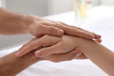 Photo of Woman receiving hand massage in wellness center, closeup