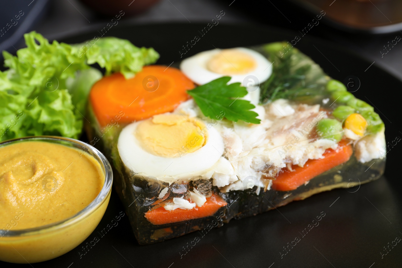 Photo of Delicious fish aspic with mustard on plate, closeup