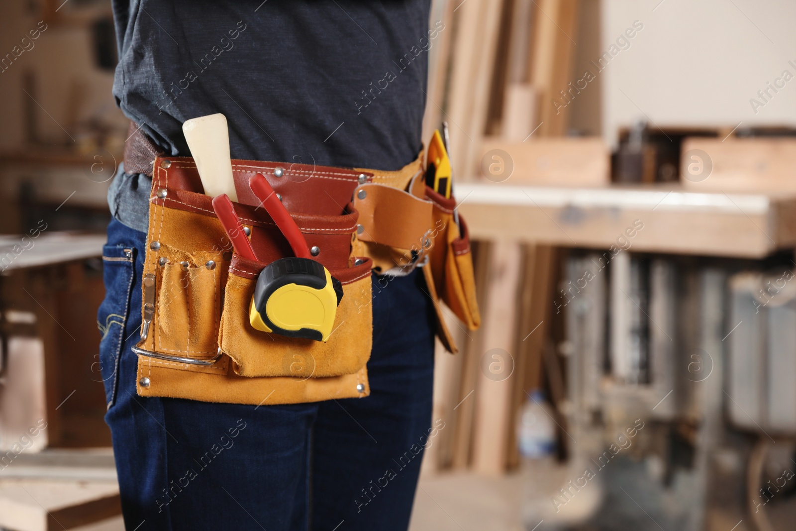 Photo of Professional carpenter with tools in workshop, closeup. Space for text