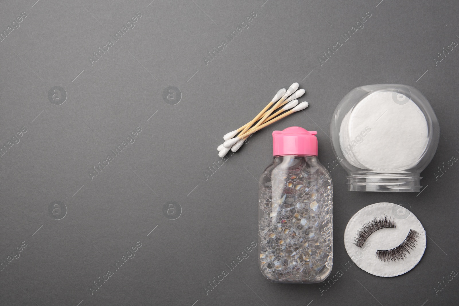 Photo of Flat lay composition with makeup removal tools and false eyelashes on dark grey background. Space for text