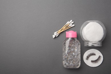 Flat lay composition with makeup removal tools and false eyelashes on dark grey background. Space for text
