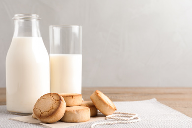 Photo of Tasty homemade cookies and milk on wooden table. Space for text