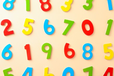 Colorful numbers on beige background, flat lay