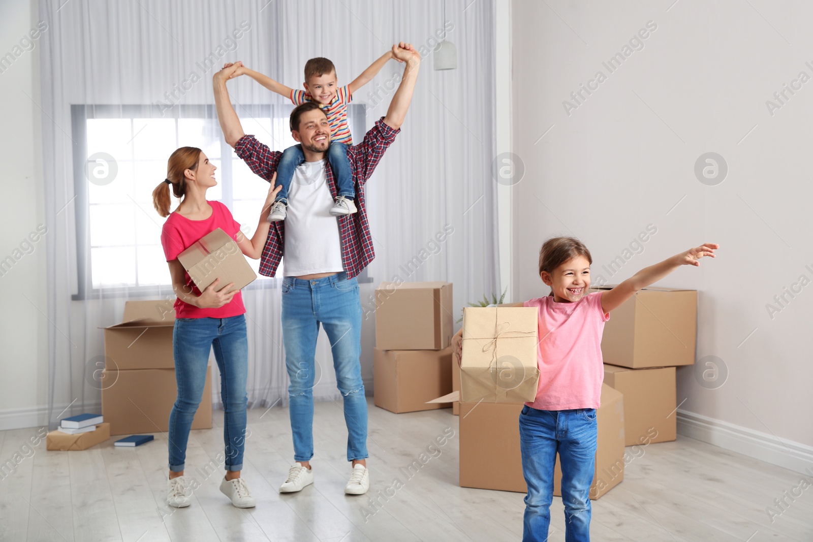 Photo of Happy family with moving boxes in their new house