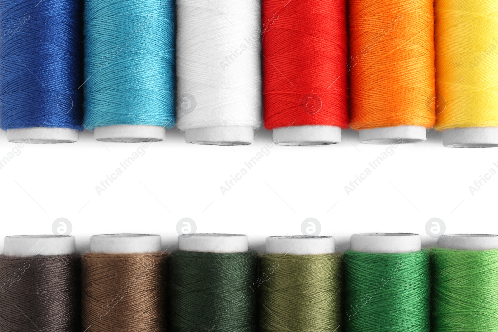 Photo of Set of colorful sewing threads on white background, flat lay. Space for text