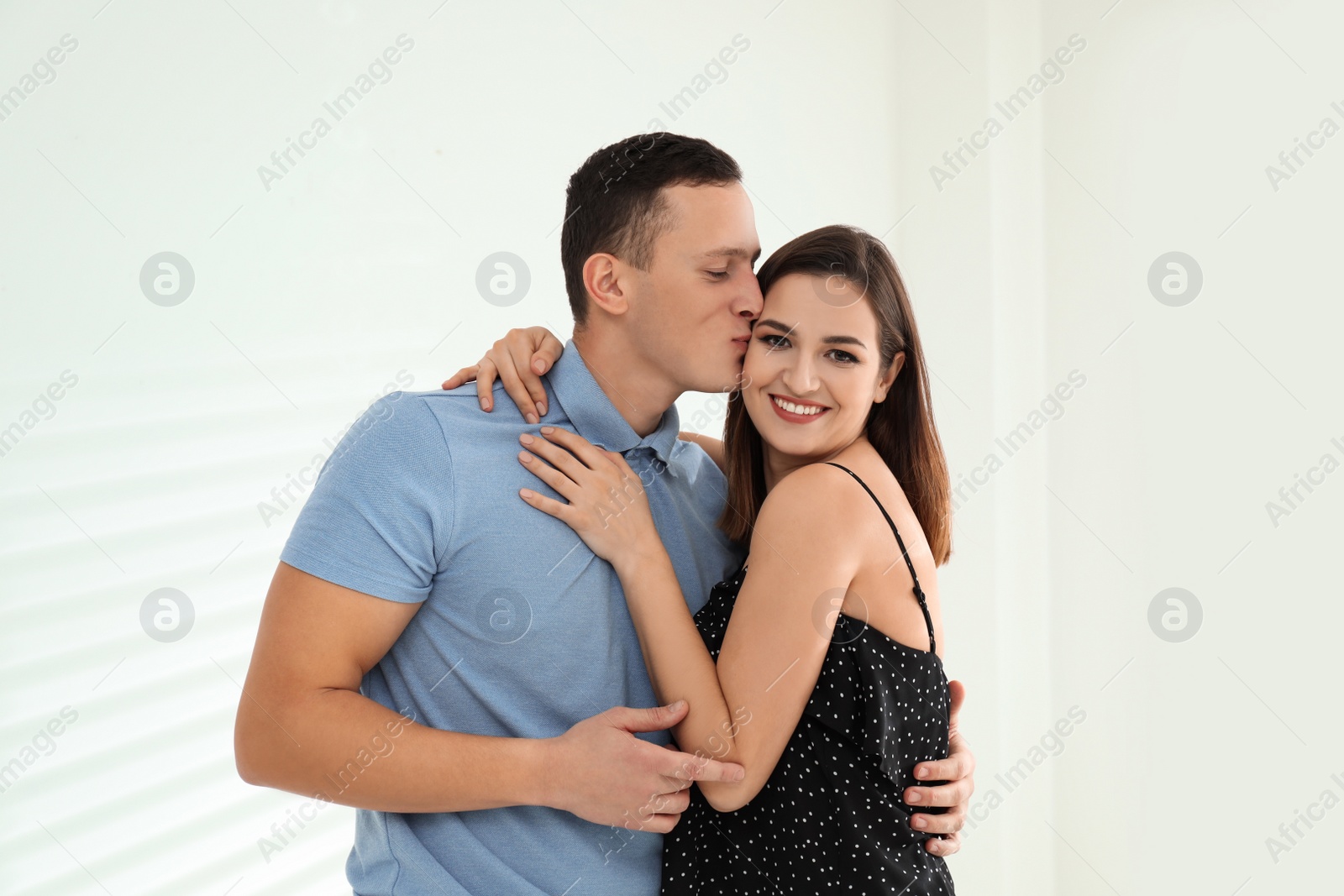 Photo of Happy young couple hugging indoors. Perfect relationship