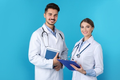 Happy young medical students on color background