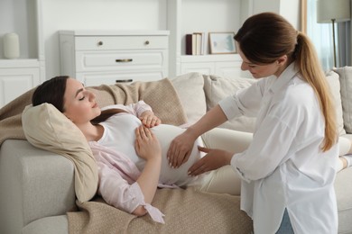 Doula taking care of pregnant woman at home. Preparation for child birth