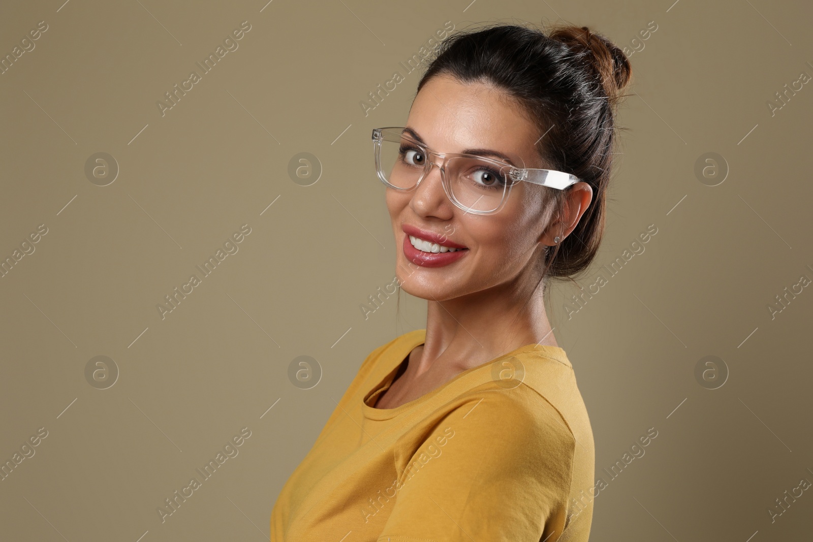 Photo of Beautiful woman in eyeglasses on beige background. Space for text